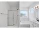 Bright bathroom boasts a glass shower, tub, window and vanity with a neutral color palette at 1203 W Escuda Rd, Phoenix, AZ 85027