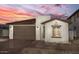 Stylish single-story home featuring brick accents, a cozy front yard, and a two-car garage at 18180 W Larkspur Dr, Goodyear, AZ 85338