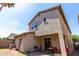Back exterior view of home showcasing a covered patio and small backyard area with grass at 18877 E Pelican Dr, Queen Creek, AZ 85142