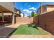 Backyard featuring an artificial turf area, brick wall, and a covered patio at 18877 E Pelican Dr, Queen Creek, AZ 85142