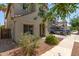 Two-story home with neutral stucco, gray shutters, a two-car garage, and mature landscaping at 18877 E Pelican Dr, Queen Creek, AZ 85142