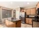 Well-lit kitchen featuring granite countertops, stainless steel appliances, and wooden cabinetry with a view into another room at 18877 E Pelican Dr, Queen Creek, AZ 85142