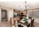 Charming kitchen and dining area with wooden cabinets, granite countertops, stainless steel appliances and chandelier lighting at 18877 E Pelican Dr, Queen Creek, AZ 85142