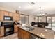 Spacious kitchen with wooden cabinets, granite countertops, and modern appliances, with an open view to the living area at 18877 E Pelican Dr, Queen Creek, AZ 85142