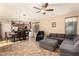 Open-concept living area with a dining table set, comfortable gray sectional sofa, and a ceiling fan for added comfort at 18877 E Pelican Dr, Queen Creek, AZ 85142