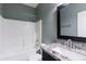Bathroom with a white shower/tub combo, a decorative mirror, and granite countertop at 2194 N Magdelena Pl, Casa Grande, AZ 85122