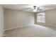 Neutral bedroom featuring carpeted floor, ceiling fan with light fixture, and window with blinds at 2194 N Magdelena Pl, Casa Grande, AZ 85122