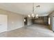 Open living area with tile and carpet flooring, custom shelving, and a stylish chandelier at 2194 N Magdelena Pl, Casa Grande, AZ 85122