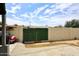 A backyard space featuring a green gate and tall fencing at 2916 N 48Th Ave, Phoenix, AZ 85031