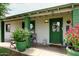 Inviting front porch with green door, potted flowers, and seating area for relaxing outdoors at 2916 N 48Th Ave, Phoenix, AZ 85031