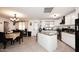 Open kitchen with an island, white cabinets, and a dining area at 2916 N 48Th Ave, Phoenix, AZ 85031