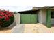 Property featuring vibrant bougainvillea next to a painted green wooden gate and covered parking at 2916 N 48Th Ave, Phoenix, AZ 85031