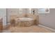 Inviting bathroom featuring a corner jetted tub, tile flooring, and decorative tile trim at 3034 E Turney Ave, Phoenix, AZ 85016