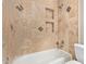 Bathroom featuring a tub and shower with tile surround and inset shelving at 3034 E Turney Ave, Phoenix, AZ 85016