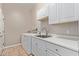 Bright laundry room features a stainless steel sink, white cabinets, and a washer and dryer at 3034 E Turney Ave, Phoenix, AZ 85016