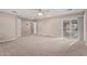Large primary bedroom featuring plush carpeting, a ceiling fan, and sliding glass doors to the patio at 3034 E Turney Ave, Phoenix, AZ 85016