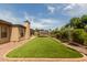 Beautiful backyard with artificial turf, mature trees, and a trampoline for outdoor fun at 317 E Harwell Rd, Gilbert, AZ 85234