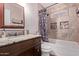 Modern bathroom with granite vanity, tiled shower with shampoo niches, and a stylish shower curtain at 317 E Harwell Rd, Gilbert, AZ 85234