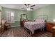 Charming bedroom with a vintage-style bed, wood-look floors, and natural light at 317 E Harwell Rd, Gilbert, AZ 85234