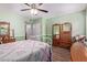 Comfortable bedroom with a patterned bedspread, wood floors, and bright green walls at 317 E Harwell Rd, Gilbert, AZ 85234