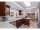 Kitchen featuring white countertops, dark brown cabinets, and views to other living spaces at 317 E Harwell Rd, Gilbert, AZ 85234