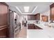 Kitchen featuring stainless steel appliances, white countertops, and dark brown cabinets at 317 E Harwell Rd, Gilbert, AZ 85234