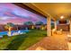 Spacious backyard with a sparkling pool, covered patio, lounge seating, and lush green lawn at 3408 E Daley Ln, Phoenix, AZ 85050