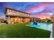 Expansive backyard with a sparkling pool, covered patio, and lush green lawn for outdoor enjoyment at 3408 E Daley Ln, Phoenix, AZ 85050