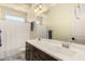 Bathroom with dark wood cabinets, double sinks, and a shower with a white curtain at 3408 E Daley Ln, Phoenix, AZ 85050
