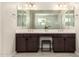 Well-lit bathroom featuring double sink vanity, dark wood cabinets, and tile flooring at 3408 E Daley Ln, Phoenix, AZ 85050