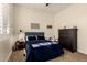 Comfortable bedroom featuring a blue upholstered headboard, plantation shutters, and dark wood dresser at 3408 E Daley Ln, Phoenix, AZ 85050