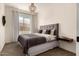 Comfortable bedroom showcases a tufted headboard, neutral color palette, and great natural light from the window at 3408 E Daley Ln, Phoenix, AZ 85050