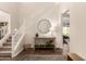 Elegant foyer with a staircase, stylish table, round mirror, and contemporary decor at 3408 E Daley Ln, Phoenix, AZ 85050
