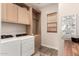Laundry room with built-in cabinets, a hanging rod and side-by-side washer and dryer at 3408 E Daley Ln, Phoenix, AZ 85050