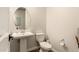Neat powder room featuring a white pedestal sink, modern toilet, and neutral decor at 3408 E Daley Ln, Phoenix, AZ 85050