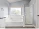 Bathroom features a soaking tub with window, a glass shower, and neutral paint at 3641 E Park Ave, Phoenix, AZ 85044