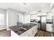 Modern kitchen island featuring white cabinets, black marble countertops, and stainless steel appliances at 3641 E Park Ave, Phoenix, AZ 85044