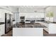 Modern kitchen island features a dark marble countertop with stainless steel appliances and sleek white cabinetry at 3641 E Park Ave, Phoenix, AZ 85044