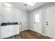 Bright laundry room featuring modern gray cabinets, black granite countertops, and vinyl plank flooring at 3641 E Park Ave, Phoenix, AZ 85044