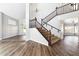 Elegant living room featuring a staircase with dark wood banister, hardwood floors, and decorative chandelier at 3641 E Park Ave, Phoenix, AZ 85044
