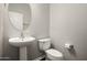 This powder room offers a pedestal sink, modern toilet, and a clean, minimalist design at 3983 E Melinda Dr, Phoenix, AZ 85050