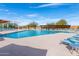 Sparkling pool with blue lounge chairs and sun shades, set against a clear blue sky, perfect for relaxation at 3983 E Melinda Dr, Phoenix, AZ 85050