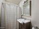 Cozy bathroom with updated vanity, mirror, and shower with patterned curtain at 405 W Monte Way, Phoenix, AZ 85041