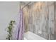 A bathtub with shower curtain and textured tiling at 405 W Monte Way, Phoenix, AZ 85041