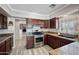 Well-lit kitchen with granite countertops, stainless steel appliances, and wood cabinets at 405 W Monte Way, Phoenix, AZ 85041