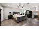 This main bedroom has a ceiling fan, dresser with TV, and a large headboard at 405 W Monte Way, Phoenix, AZ 85041
