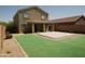 View of the grassy backyard with concrete patio, desert landscaping, and rear of home at 43241 W Kristal Ln, Maricopa, AZ 85138