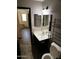 A partial view of a bathroom with a sink, toilet, metal shelving and a glimpse into hallway with staircase at 43241 W Kristal Ln, Maricopa, AZ 85138