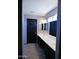 Bathroom featuring a double sink vanity with white countertop and a black door at 43241 W Kristal Ln, Maricopa, AZ 85138