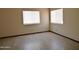 Bright bedroom featuring wood-look vinyl floors and two windows at 43241 W Kristal Ln, Maricopa, AZ 85138